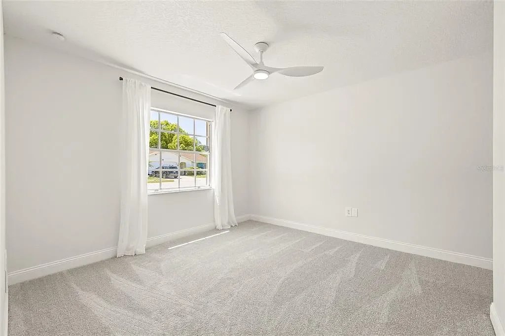 Bright carpet bedroom with window — Holiday, FL