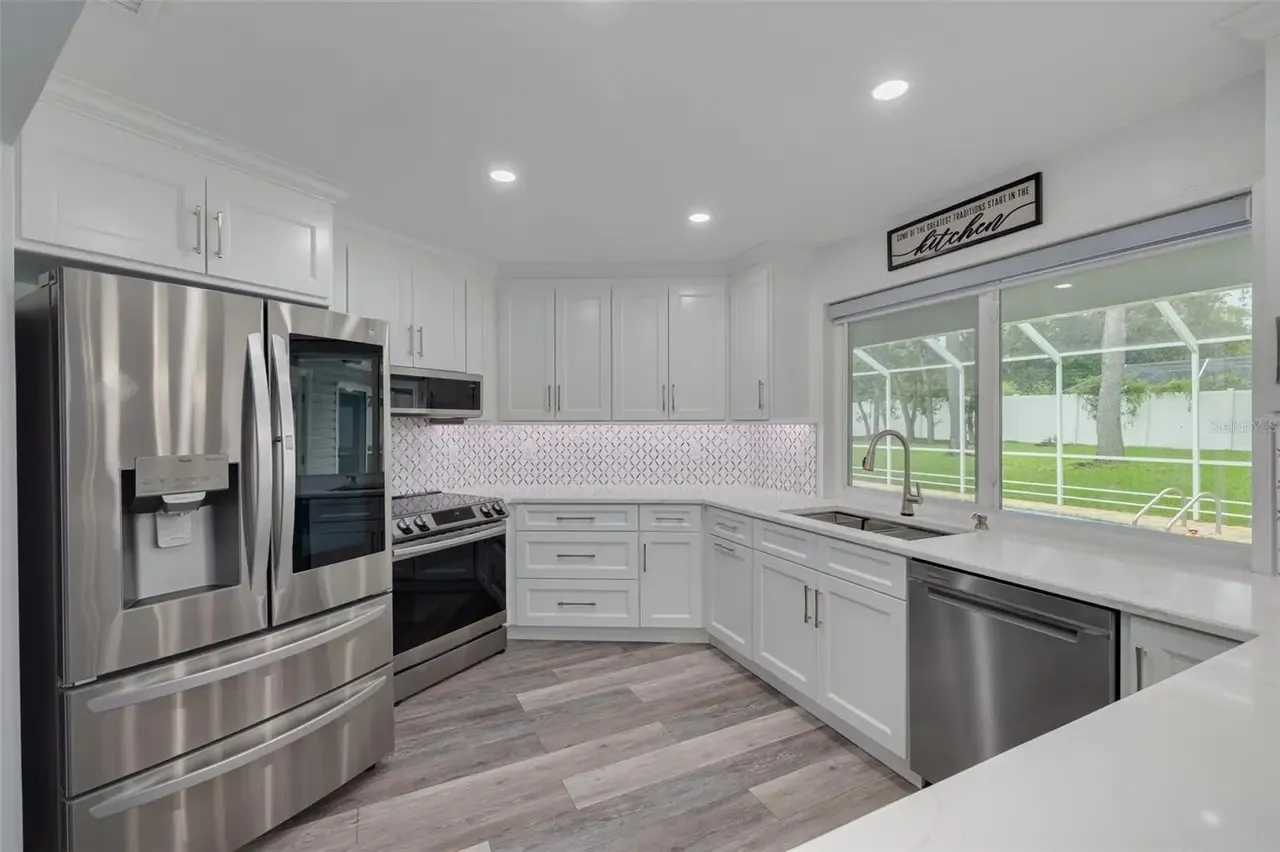LVP kitchen white cabinets tile backsplash Holiday FL