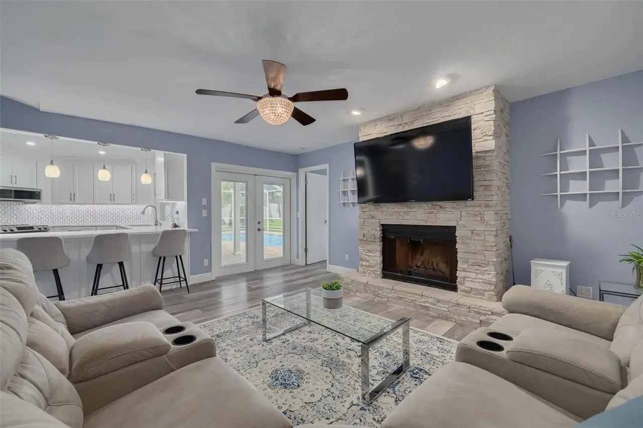 LVP living room stone fireplace kitchen view Holiday FL